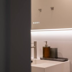 Detalle del lavabo con grifería moderna y dispensadores en el baño del departamento Jacobine, gestionado por Stag Properties