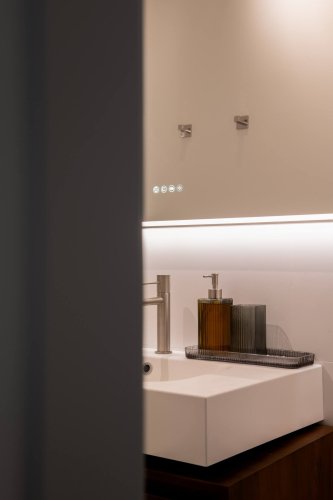 Detalle del lavabo con grifería moderna y dispensadores en el baño del departamento Jacobine, gestionado por Stag Properties